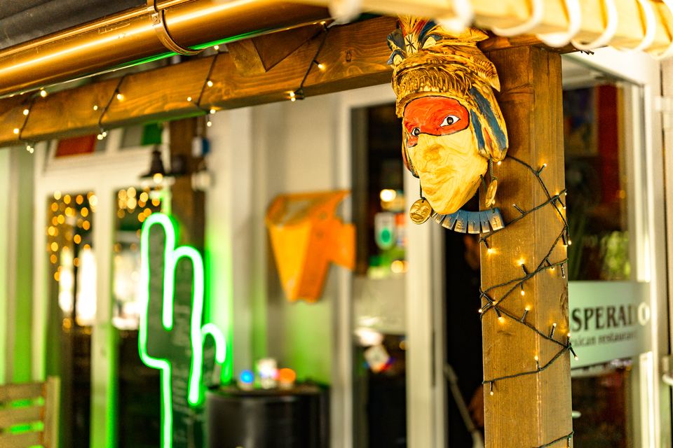 Neon-Kaktus und Maske am Eingang der Terrasse